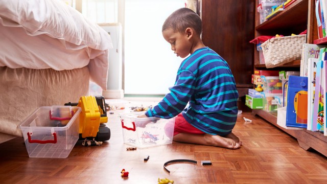 little boy helping to clear the clutter from his room.