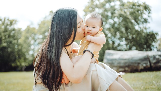 a mom snuggling her baby in the park which makes a great pic for baby's photo album