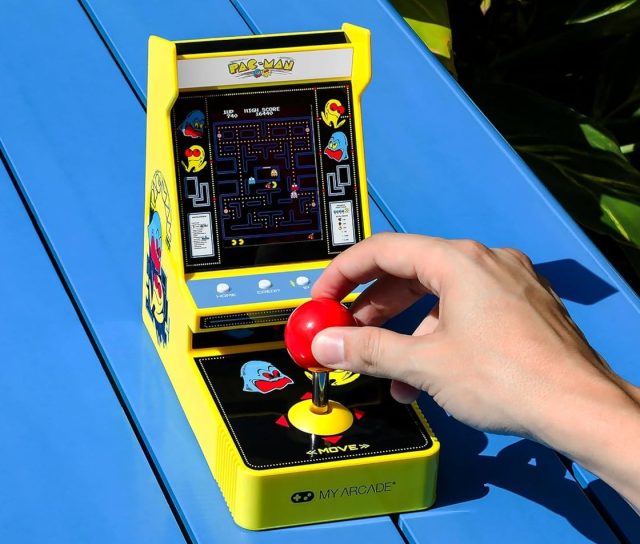 the arcade game being played on a blue picnic table
