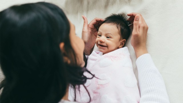 a newborn baby smiling at their mother in one of their newborn photos