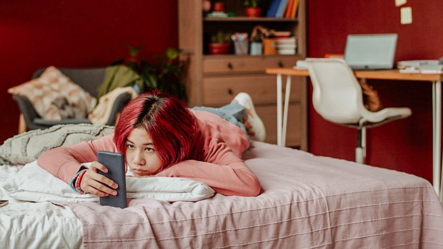 teen girl on her cellphone at night in her room
