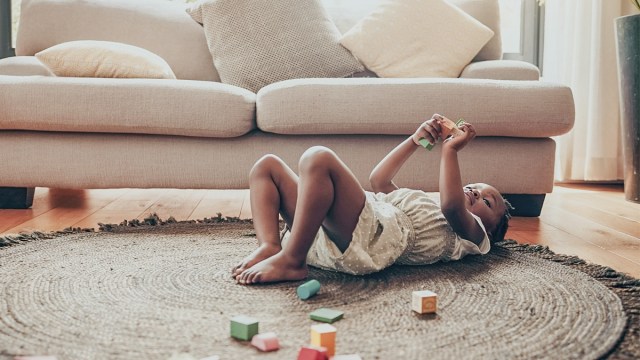 a tired toddler playing while her mom probably wonders when do toddlers drop naps