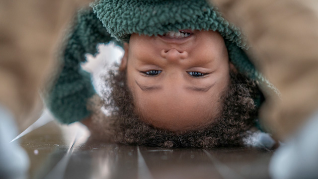 little toddler playing peek-a-boo