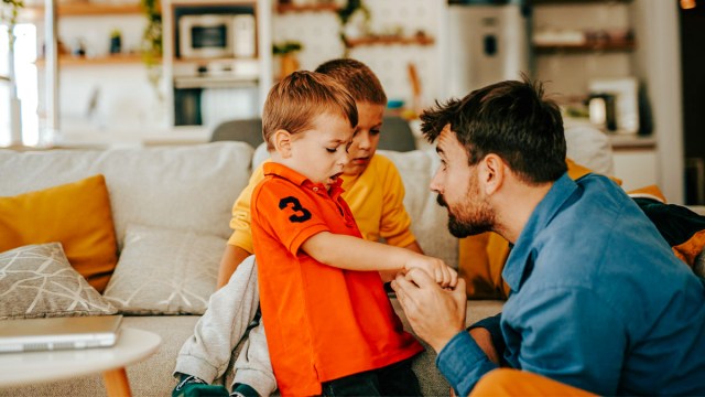 a dad dealing with his little kid's toddler hitting by holding his hands